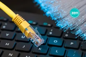 Yellow Ethernet cable, fiber optics, and a Zen logo on a laptop keyboard.