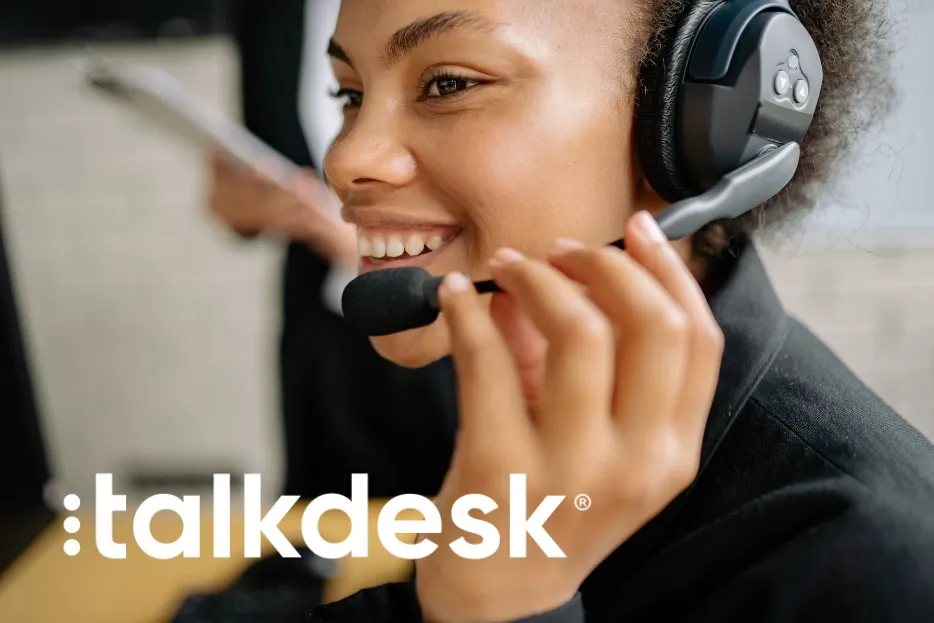 Smiling woman in headset with microphone, representing Talkdesk customer service.