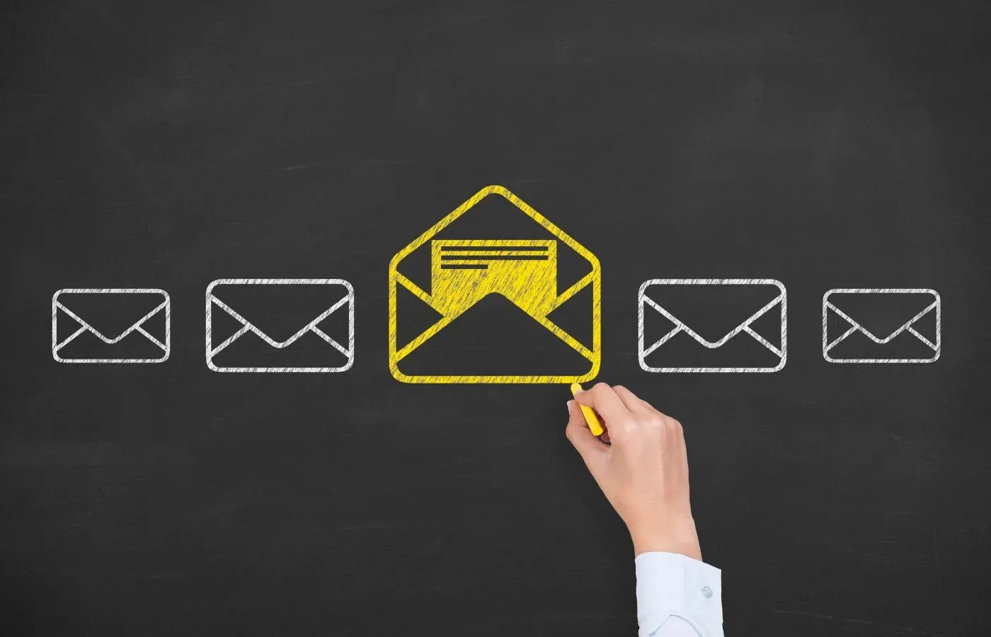 A hand draws an open yellow email icon among closed white envelopes on a black background.