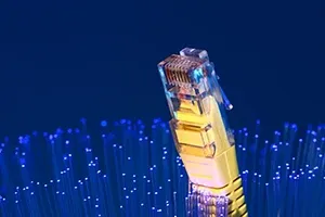 A yellow Ethernet connector stands against a blue background with glowing fiber optic strands.
