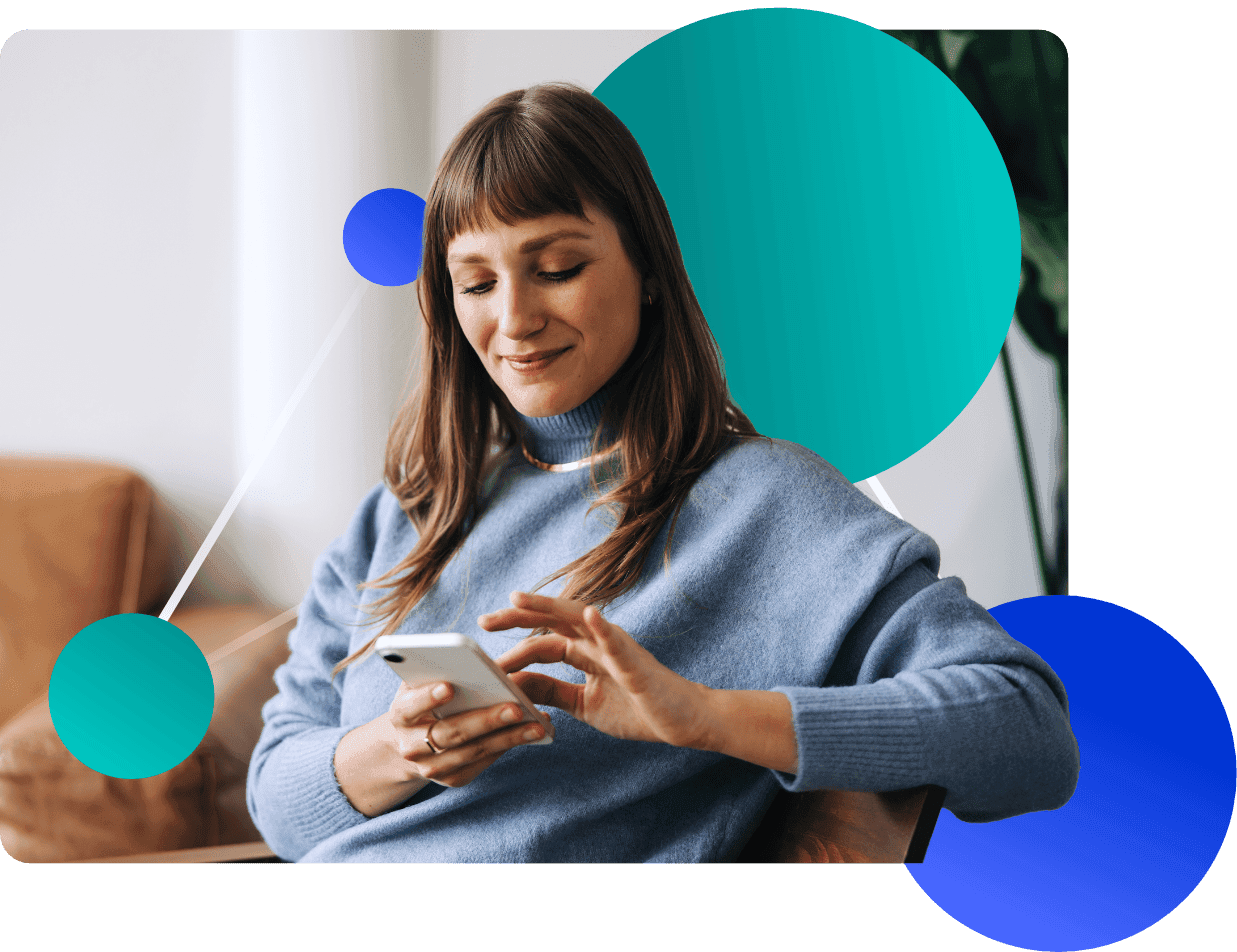 Smiling woman in a blue sweater checking her phone with colorful abstract shapes.