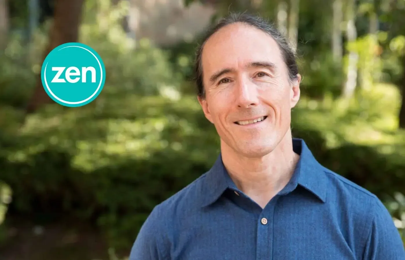 Smiling man in blue shirt with dark hair, green background, and 'zen' logo.